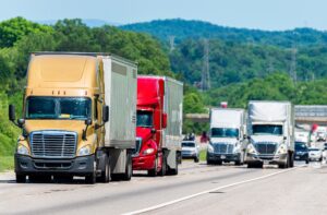 Trucks in convoy on an interstate highway.