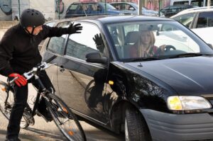 Bicycle rider in danger when the driver making a left turn without signal.