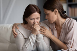 Caring adult daughter comforting soothing sad middle aged mother.