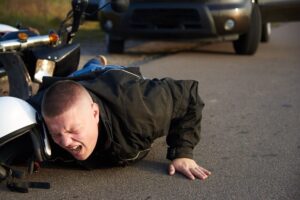 Motorcycle rider feeling pain from accident.