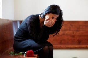 Crying woman in the chapel for her late husband memorial.