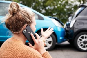 Lady driver calling police to report accident.