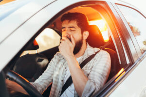 Sleepy driver yawning early in the morning.