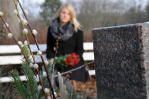 Sad woman visiting the grave of her late husband.