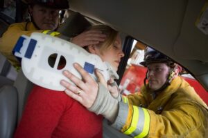 Firefighter rescuing victim from car crash.