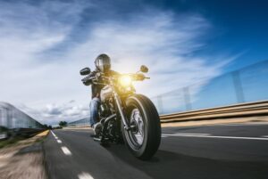 Motorcycle rider in full safety gear passing the highway.