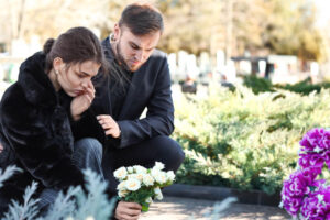 Couple sad in the funeral of their parents.